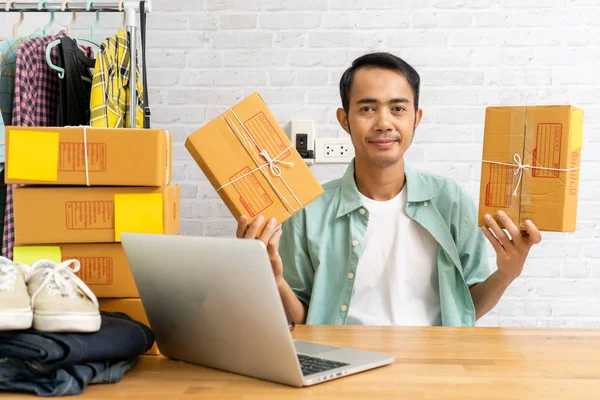Азіатський чоловік починає займатися невеликим бізнесом, тримаючи кардвар на упаковці. — стокове фото