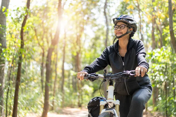 Sênior asiático mulher andar de bicicleta no parque — Fotografia de Stock