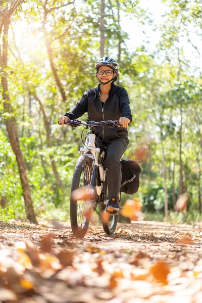 Senior asiatico donna equitazione biciclette in parco — Foto Stock
