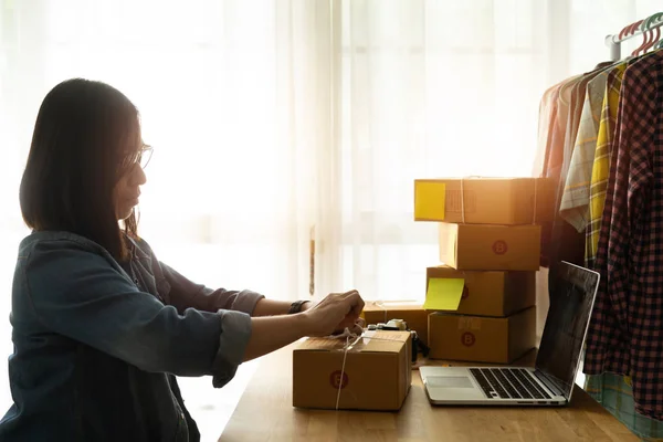 Власник жіночого бізнесу працює вдома, з упаковкою картонної коробки — стокове фото
