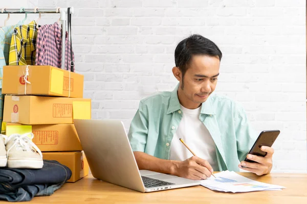 自宅のオフィスで働くスマートフォンを使用してアジアの男 オンライン販売は 中小企業の所有者の電子商取引のアイデアの概念を起動します — ストック写真