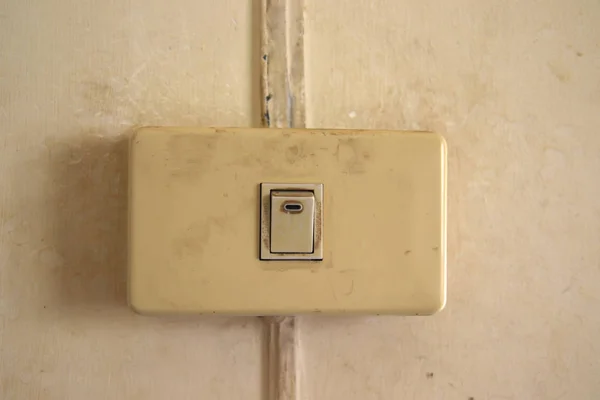 Old Single white light switch on wall,old Single Electrical on off switch that have been used for a long time on the white wall — Stock Photo, Image