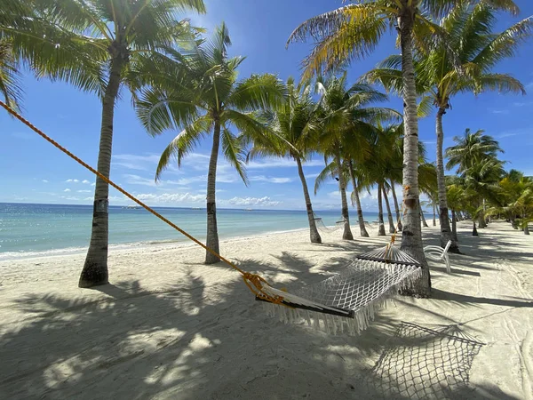 Hamac relaxant dans une forêt de palmiers gros plan. Beau paysage sur une plage de sable blanc. Bateaux sur le fond de la mer turquoise et le ciel bleu avec des nuages. Le concept de voyage et de loisirs — Photo