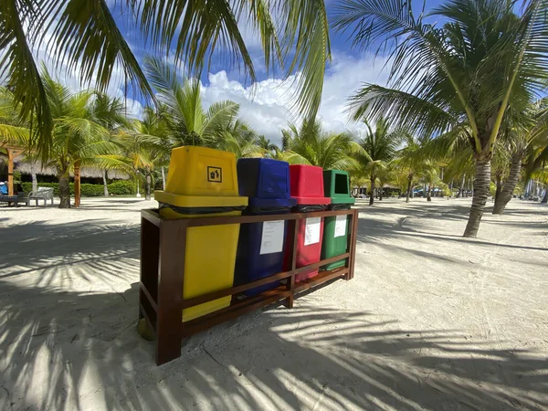 Latas de lixo coloridas, recipiente em uma praia de areia branca em uma floresta de palmeiras. Ecológico, eliminação de resíduos . — Fotografia de Stock