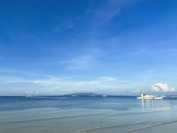 Tek renkli güzel mavi gökyüzü ve sakin deniz manzarası. Ufukta gemiler ve gemiler görünüyor..