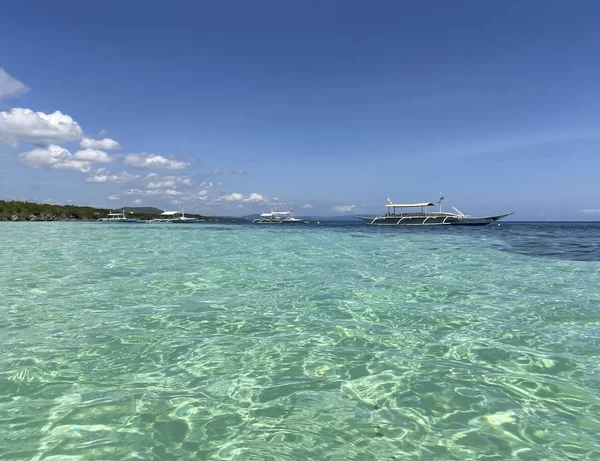 透き通ったターコイズブルーの水と水平線の上のボートで美しいリゾートの信じられないほどの風景雲と青い空 — ストック写真