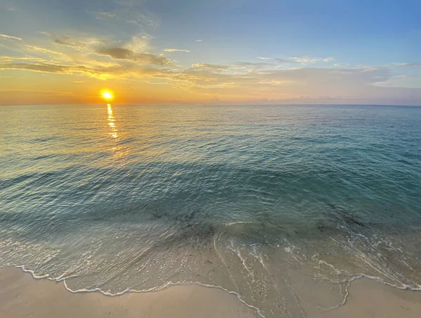 Güzel, romantik gün batımı, ufukta gün doğumu. Kumsal, turkuaz deniz.