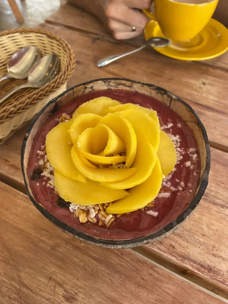 Meyve suyu kasesi. Sağlıklı beslenme. Mango deseni. Hindistan cevizi kabuklu kahvaltı. 