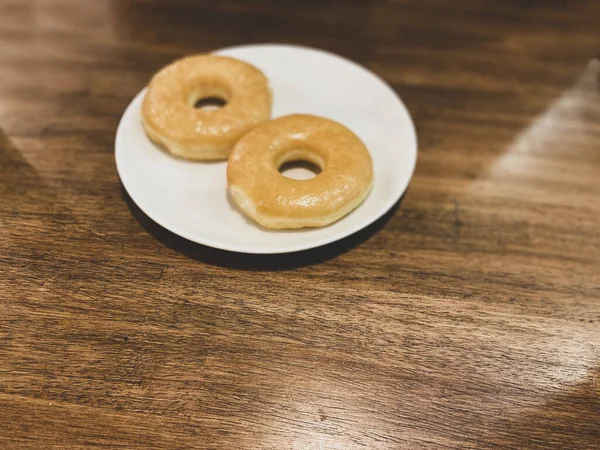 Lezzetli tatlı çörekler tabakta. Tahta masada yemek. Sağlıksız yiyecekler.