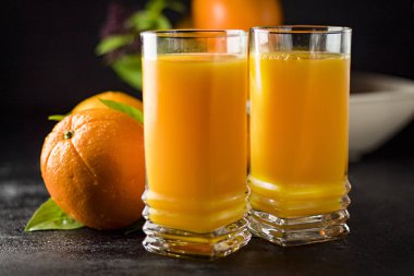 Siyah arkaplanlı bir bardak taze portakal suyu. - Görüntü