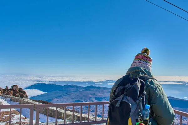 Χειμώνα ντυμένος κορίτσι βλέποντας τη θέα από την κορυφή του βουνού με φόντο ένα μπλε ουρανό — Φωτογραφία Αρχείου