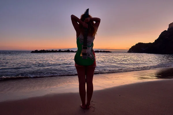 İspanya, Kanarya Adaları, Tenerife sahilinde elektro gitarlı bir kız.