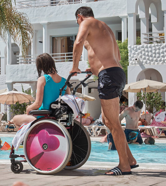 person in a wheelchair in an area for swimming in the pool