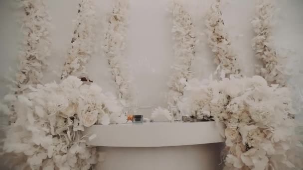 Hall διακόσμηση με λευκό τραπέζι διακοσμημένο με λουλούδια — Αρχείο Βίντεο