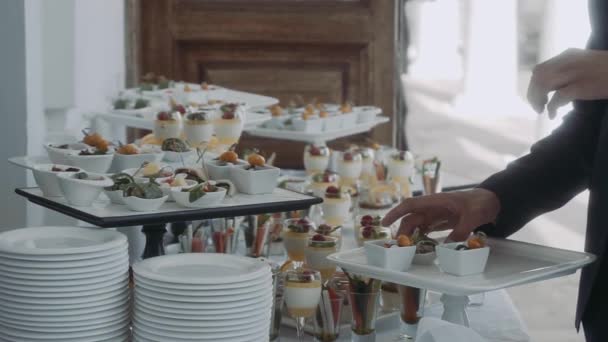 Na mesa de buffet um homem toma lanches — Vídeo de Stock