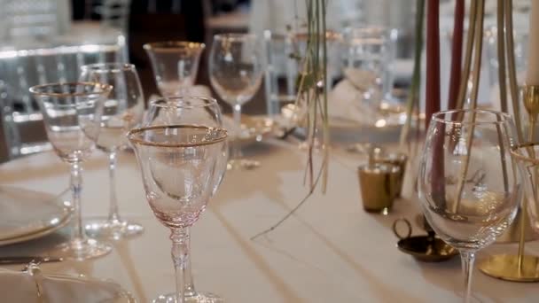 多くの透明なガラスは白いテーブルクロスとテーブルの上に立っています — ストック動画