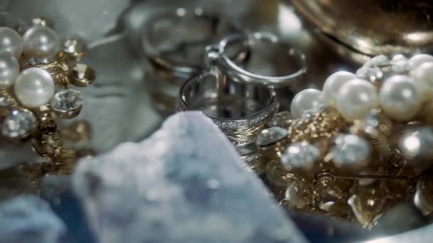 Anillos Oro Blanco Varios Adornos Yacen Sobre Mesa Están Cubiertos — Vídeo de stock