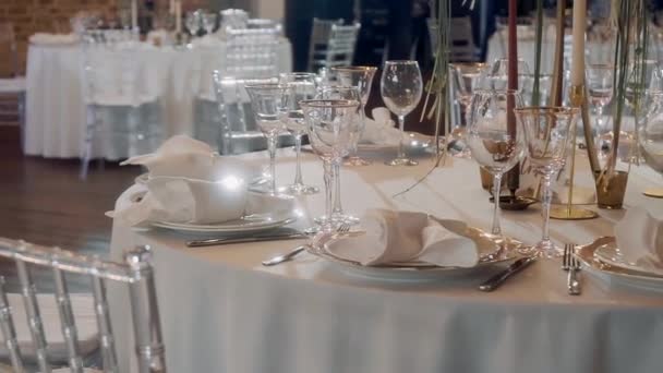 De nombreux verres transparents se tiennent sur une table avec une nappe blanche 