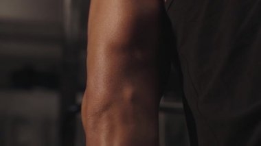 Spor salonunda dersler. Erkek kasları şişmiş. Kas çalışması yakın plan.