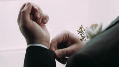 Ceketli bir adam beyaz kelepçeleri düzeltir.