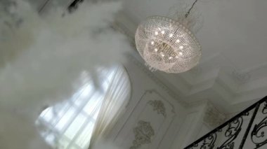  Beyaz avizedeki metal broşürler. Tavanda asılı olan alışılmadık bir avize deseni..