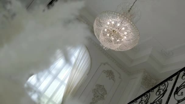 白いシャンデリアの上に金属のチラシ 天井に掛けられたシャンデリアの珍しいパターン — ストック動画