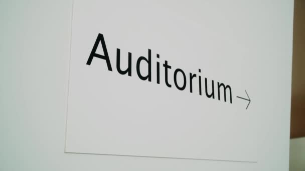 指示观众的标牌 在白色的墙上用黑色的字母写着礼堂 — 图库视频影像