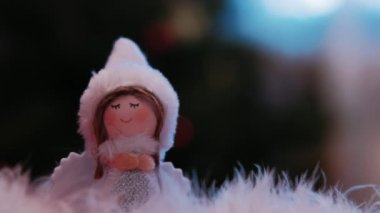 Yeni yıl oyuncakları. Mutlu Noeller ve kar yağan yeni yıl tebrik kartı ve mesajınız için yer kopyalama. Beyaz parıltılı arka plandaki küçük melek..