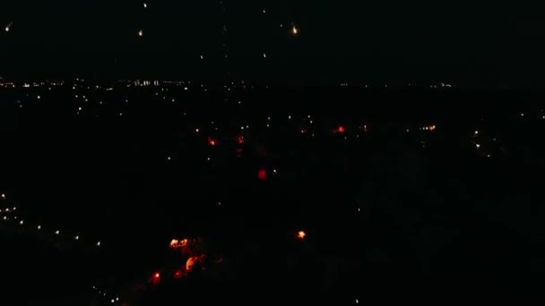 Feux d'artifice dans le ciel de la ville. Scène de drone aérien. Lumières nocturnes de ville. La caméra tourne en demi-cercle et on voit comment les feux d'artifice explosent. Images 4K .