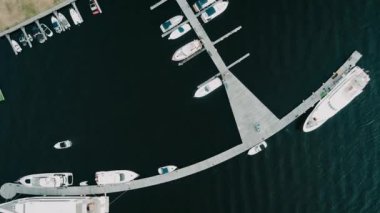 Yatlar ve yelkenliler için ranza. Denizde Sabah. Aero video çekimi. Birçok farklı yat, iskeleye demirlemiş katamaranlar..