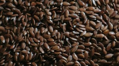 Doğal besin arkaplanı veya tahıl dokusu olarak kahverengi keten tohumu tohumları. Omega 3 yağ asitleriyle dolu keten tohumları. Yukarıdan aşağıya doğru. Sağlıklı beslenme organik besin