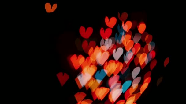 バレンタインデーの背景 アルファクリップで抽象的なカラフルな心と粒子を飛んで孤立黒の背景ループ アニメグリーティングカードやバナーのデザイン — ストック動画