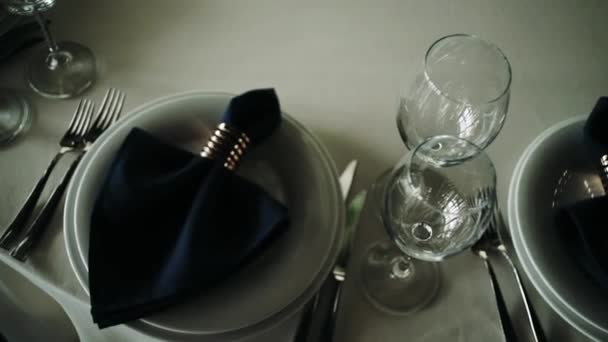 Un serveur met la table dans un restaurant avant l'arrivée des clients et utilise des couverts et des verres fins. Concept de : restauration, design, dîners romantiques 