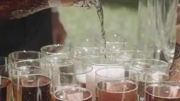 侍者在婚礼上把香槟酒倒在玻璃杯上 — 图库视频影像