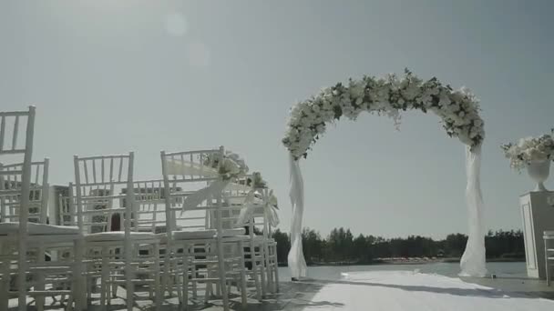 Boog Bloemen Voor Registratie Aan Het Water Met Witte Stoelen — Stockvideo