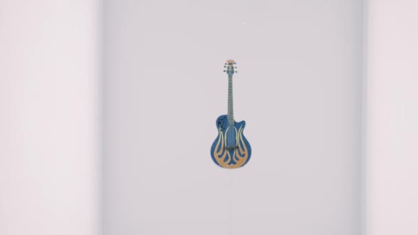 玻璃杯后面的一个盒子里 立着一把带有有趣图案的蓝色小吉他 — 图库视频影像
