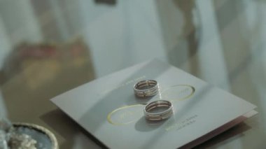 Evlilik yüzükleri davetiye zarflarının yanında ve parfüm kutuları.