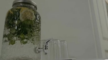 Masada gözlüklü limonatanın olduğu musluğu olan büyük cam bir kavanoz.