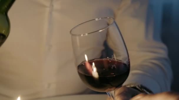 Man Pours Red Wine Bottle Glass Candles Burning Valentine Day — Stock Video