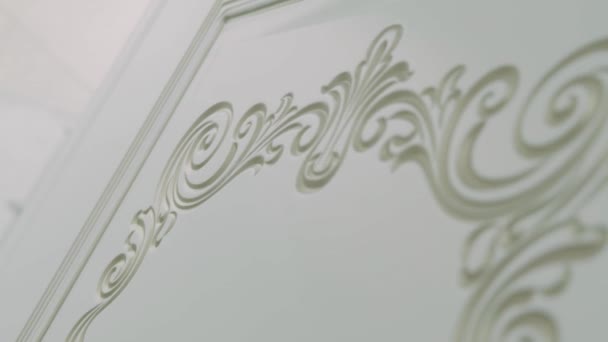 Beautiful curlicues on a white door. Decor lines with indentations on a white wooden door — Stock Footage Beautiful Curlicues White Door Decor Lines Indentations White Wooden Door Video Clip