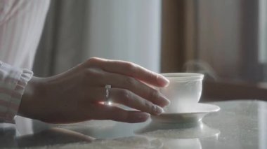  Kadın eli sıcak kahve lattesi alır. Kadın eli kahve fincanı alıyor.