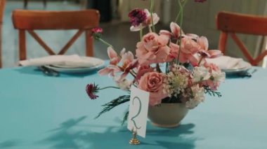 winter decor of a wedding banquet hall with blue tablecloths and beautiful soft pink flowers