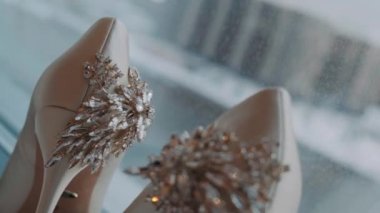 beige shoes stand with a beautiful decoration on the back stand on the window