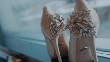 beige shoes stand with a beautiful decoration on the back stand on the window
