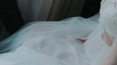 Female legs near the window on a cloudy winter day close-up female hand on a white bed