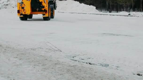 拖拉机在冬天清扫雪地 橙色拖拉机与水桶一起工作 — 图库视频影像