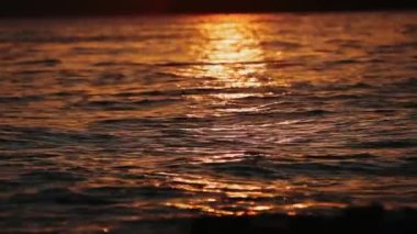 Denizde kızıl gün batımı. Güneş ufukta beliriyor. Kızıl gökyüzü, sarı güneş ve inanılmaz deniz. Yaz günbatımı deniz manzarası. Atlantik Okyanusu plaj günbatımı. Güneş dönen bulutlarda. İnanılmaz doğal gün batımları.