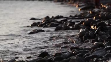 Deniz öğleden sonra yakın çekim. Dalgalar taşlara sıçrıyor