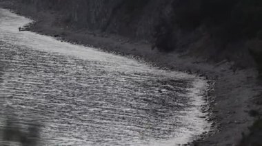 Deniz öğleden sonra yakın çekim. Dalgalar taşlara sıçrıyor