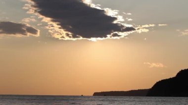 Denizde kızıl gün batımı. Güneş ufukta beliriyor. Kızıl gökyüzü, sarı güneş ve inanılmaz deniz. Yaz günbatımı deniz manzarası. Atlantik Okyanusu plaj günbatımı. Güneş dönen bulutlarda. İnanılmaz doğal gün batımları.